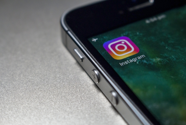 5 Ways Companies Can Generate Business Results Through Instagram - An iphone 4 with only a portion of the screen showing on the left hand side of the screen. On the screen the only app is the instagram icon
