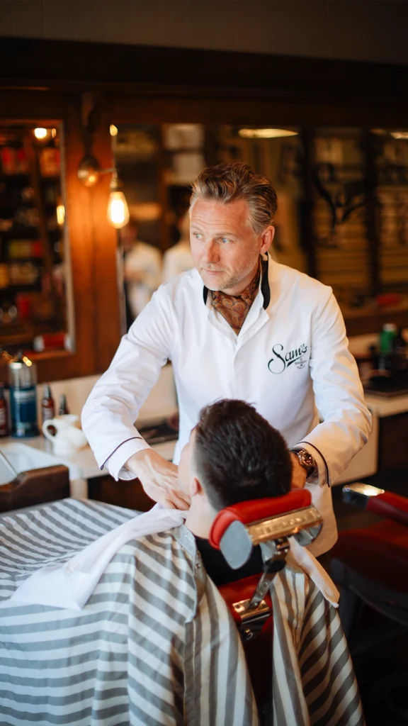 Barber gives a haircut in a stylish Dublin barbershop with vintage decor.